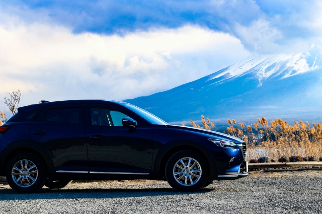 青い車の側面に富士山の背景